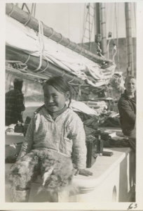 Image of Little Eskimo [Inuk] girl sitting on cabin (Etookashoo's daughter)